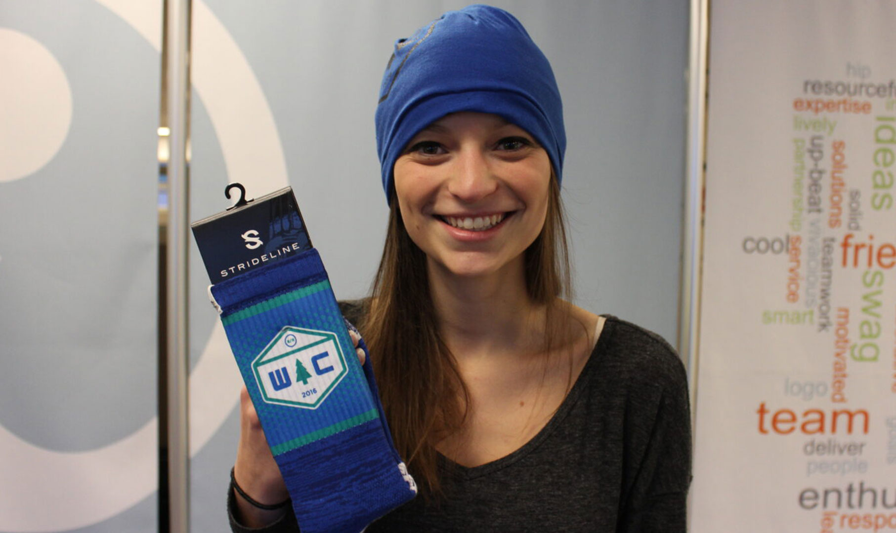 Image of woman holding socks and wearing blue beanie.