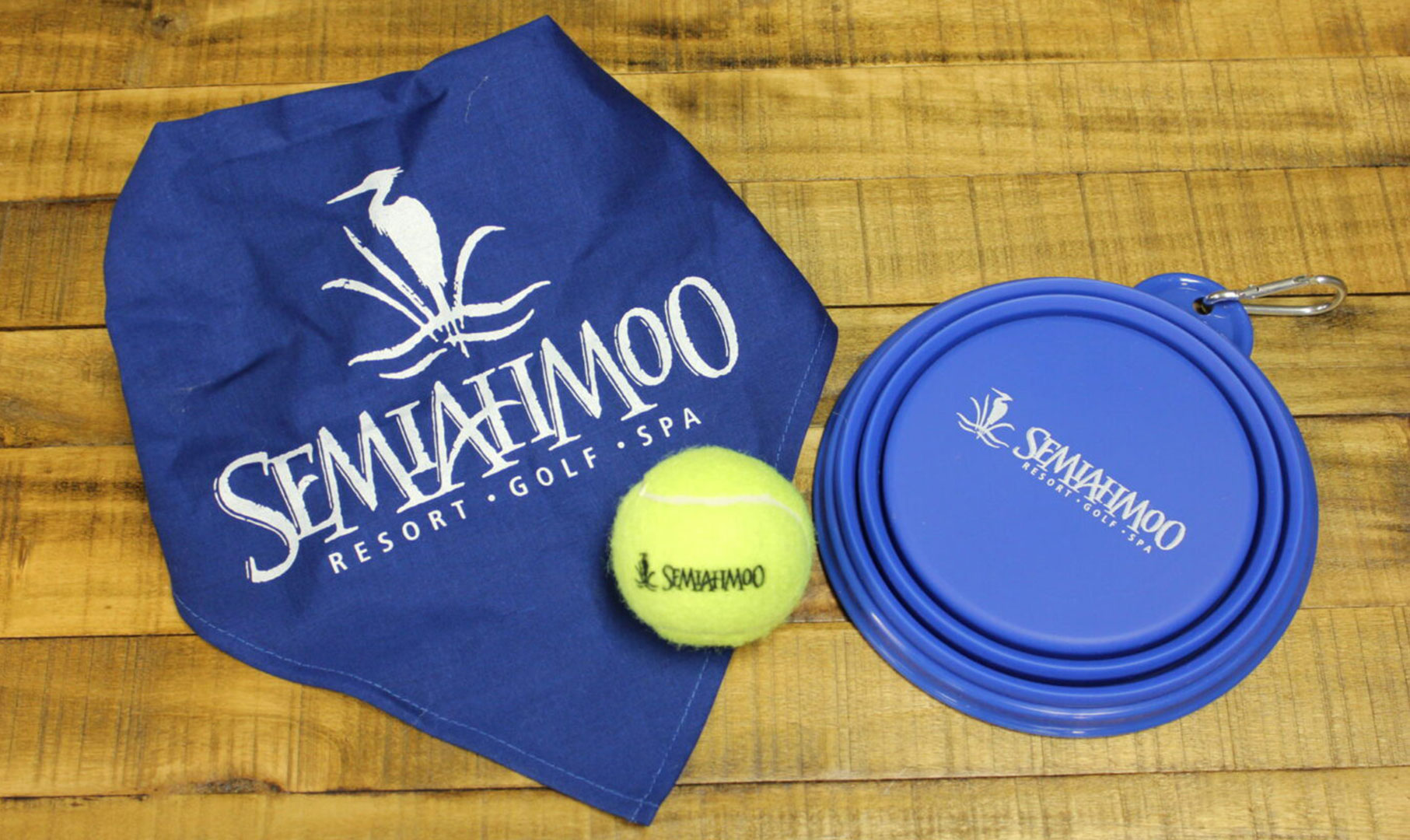 Blue dog bandana, tennis ball and collapsible water bowl with Semiahmoo logo on it.