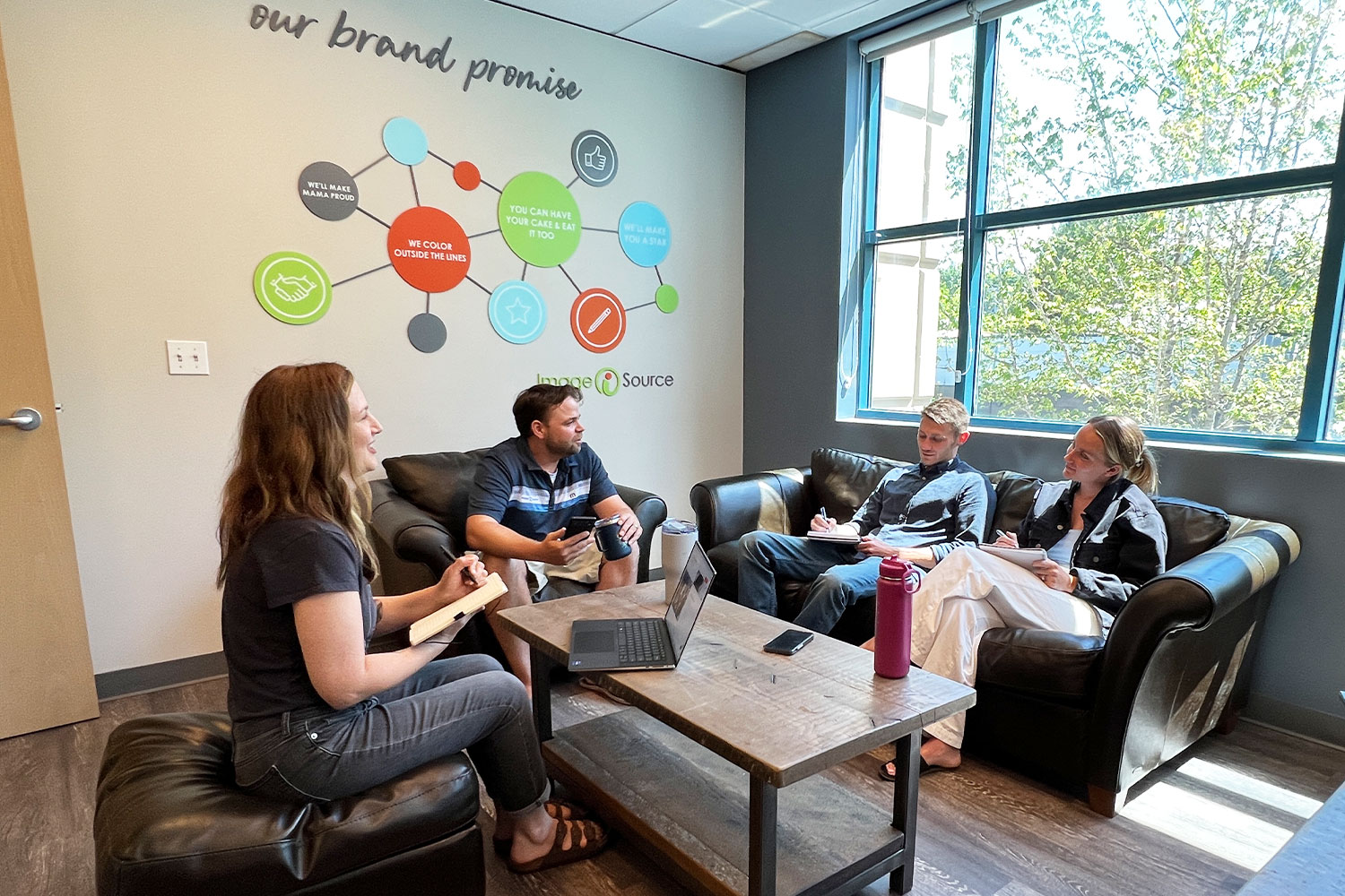 Group of four people sitting around a table having a meeting.