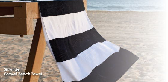Black and white striped towel hanging off beach railing