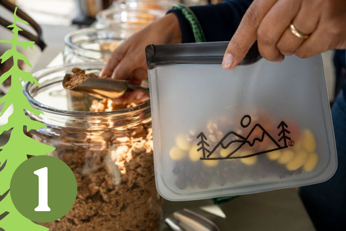 Person scooping granola into a ziplock bag.