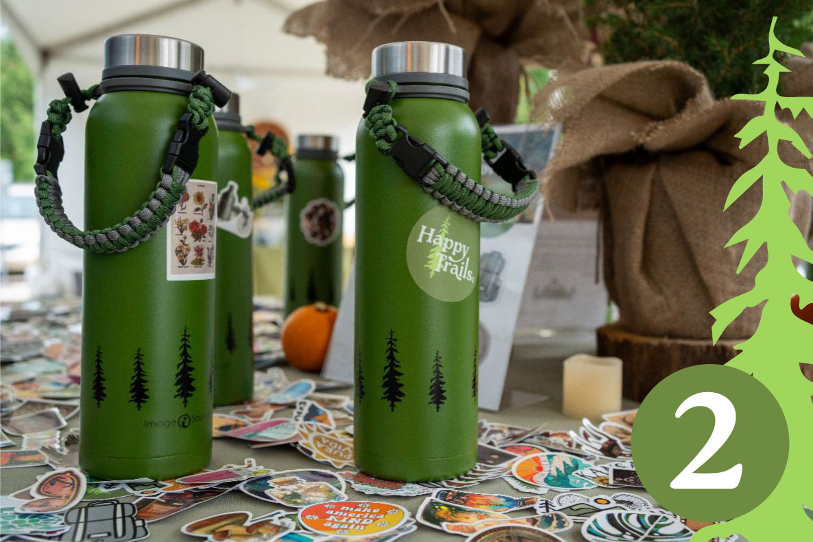 Table with pile of stickers on it and a few water bottles with stickers on them for display..