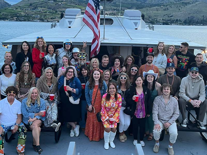 Group of people dressed in disco outfits on a party boat.