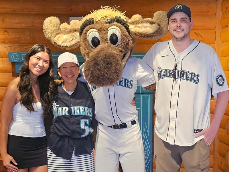 Three people posing with Mariner Moose.