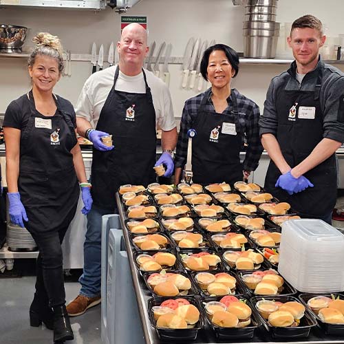 Four people preparing bulk meals.
