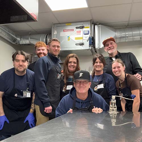 Eight people in industrial kitchen.