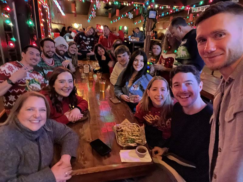 People in holiday sweaters at a pub.