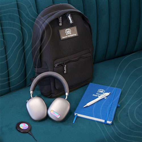 Kit_Square Black backpack with silver headphones on blue bench.