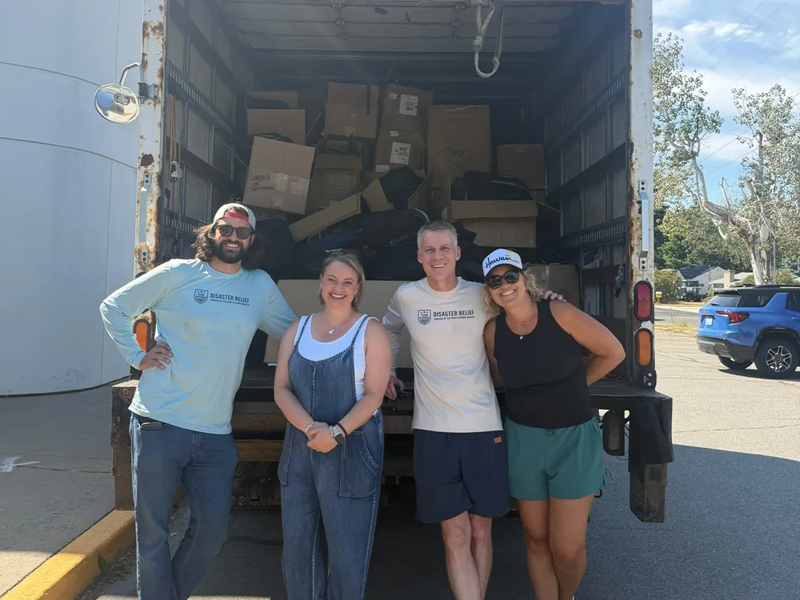 Delivery Four people posing in front of packed delivery truck.