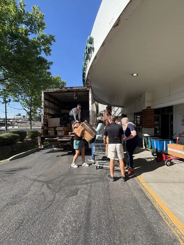 Truck People unloading a delivery truck full of supplies.